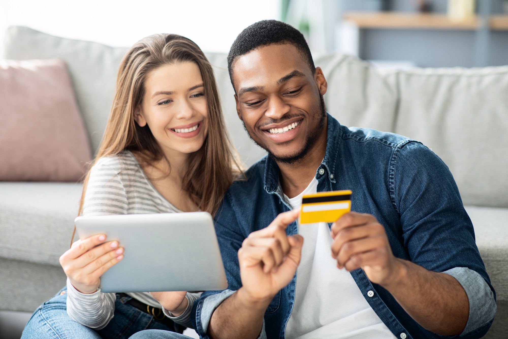 E-commerce Concept. Interracial Couple Shopping Online With Digital Tablet And Credit Card
